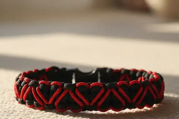 Dettaglio dei cuori rossi intrecciati nel bracciale in Paracord nero